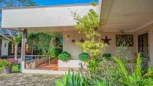 A building with a covered entrance, outdoor seating area, and decorative star wall art. - Hotel Zima (San Isidro de El General)