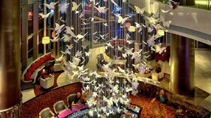 A spacious lobby with a central atrium, featuring a unique hanging sculpture of white birds and abstract shapes. - Radisson Blu Plaza Bangkok (Bangkok)