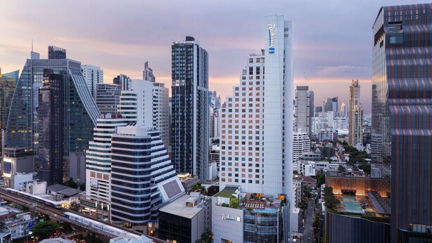 Un paisaje urbano moderno con rascacielos, incluyendo un destacado hotel Radisson.
