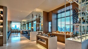 A modern hotel lobby with a marble floor, seating area, and a view of the city skyline through large windows. - Radisson Blu Plaza Bangkok (Bangkok)
