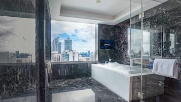 A modern bathroom with a large mirror, a bathtub, and a glass-enclosed shower area.