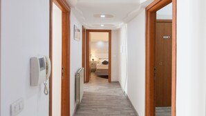 Un pasillo estrecho con puertas de madera y un radiador en la pared.
