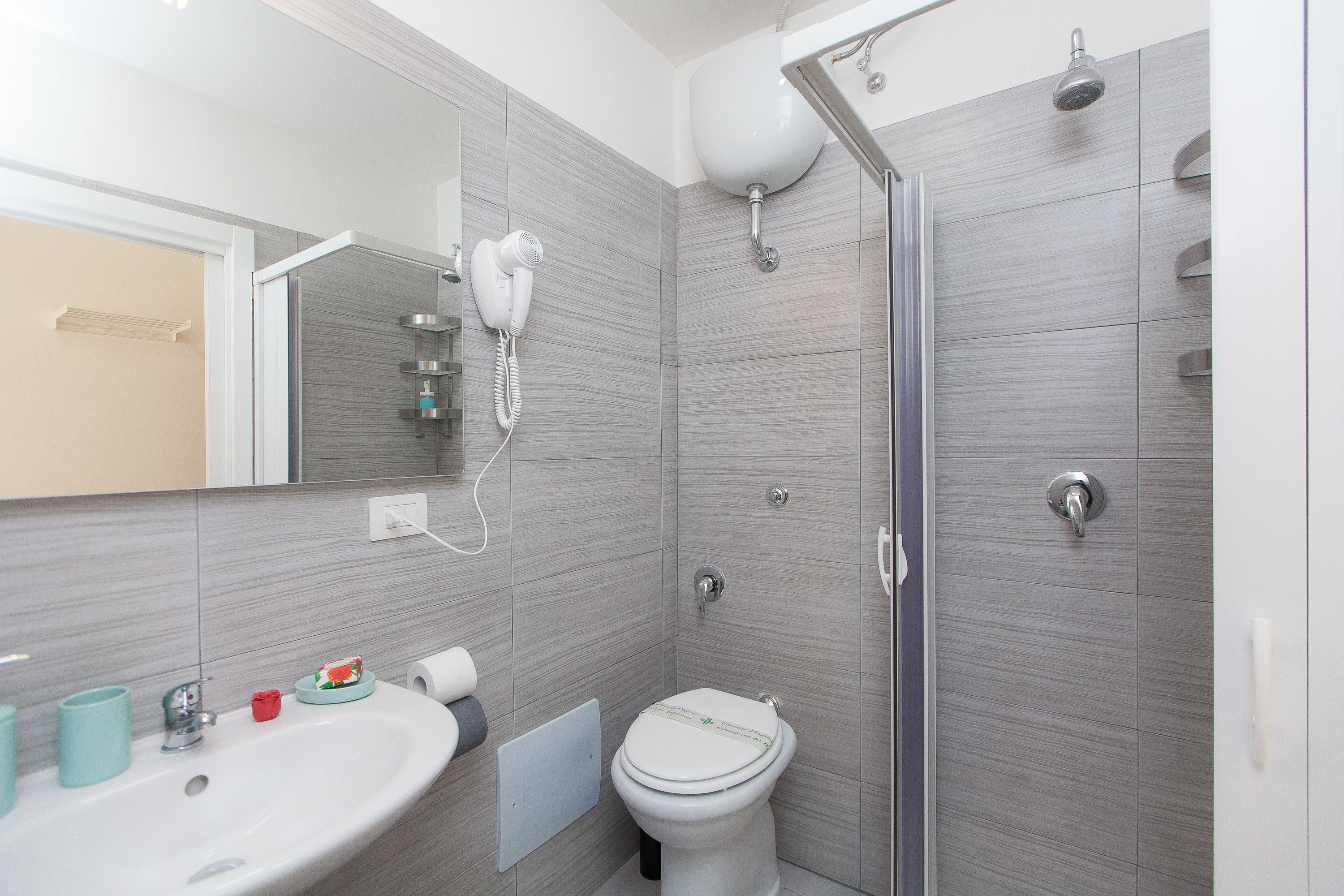A modern bathroom with a sink, toilet, and shower.