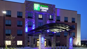 Un hôtel Holiday Inn Express & Suites doté d’une architecture moderne, avec une enseigne lumineuse bien visible et un espace d’entrée abrité.