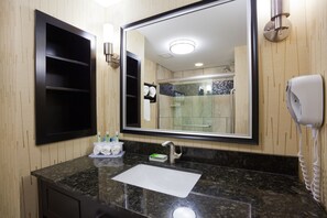A bathroom with a large mirror, a sink, and a hairdryer. - Holiday Inn Express Hotel & Suites Fort Dodge by IHG (Fort Dodge)