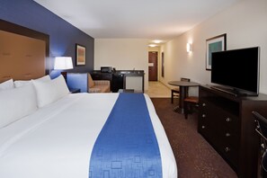 A hotel room with a large bed, a desk with a computer, a television, and a dining area. - Holiday Inn Express Hotel & Suites Fort Dodge by IHG (Fort Dodge)
