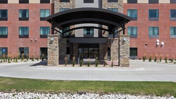 A Holiday Inn Express & Suites building with a stone facade, multiple windows, and a covered entrance.