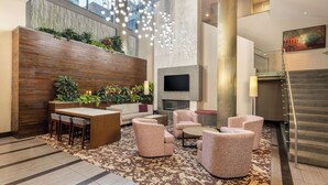 Eine moderne Lobby mit Holzbude, Sitzgruppe und einer Treppe.