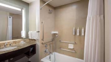A modern bathroom with a bathtub, shower, and vanity.