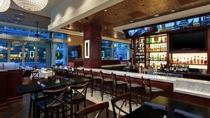 Ein Barbereich mit Sitzgelegenheiten, einer Bar und einem Fernseher.