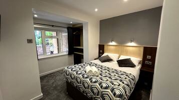 A bedroom with a bed, bedside tables, a window, and a built-in wardrobe.
