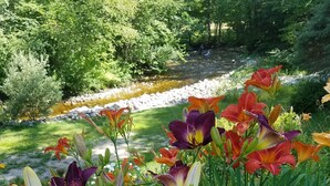 A garden with various flowers and a stream. - Toll Road Inn (Manchester Center)