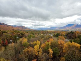 Paisaje montañoso con follaje otoñal y un valle.