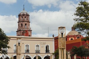 Un hotel con una imponente torre de reloj y una cúpula, que cuenta con balcones y un estilo arquitectónico clásico.