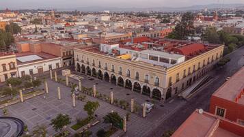 A hotel with a central courtyard, multiple floors, and a red roof.