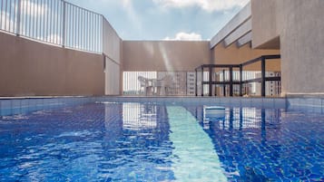 Una piscina al aire libre, sillones reclinables de piscina