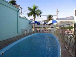 Een buitenzwembad, parasols voor strand/zwembad