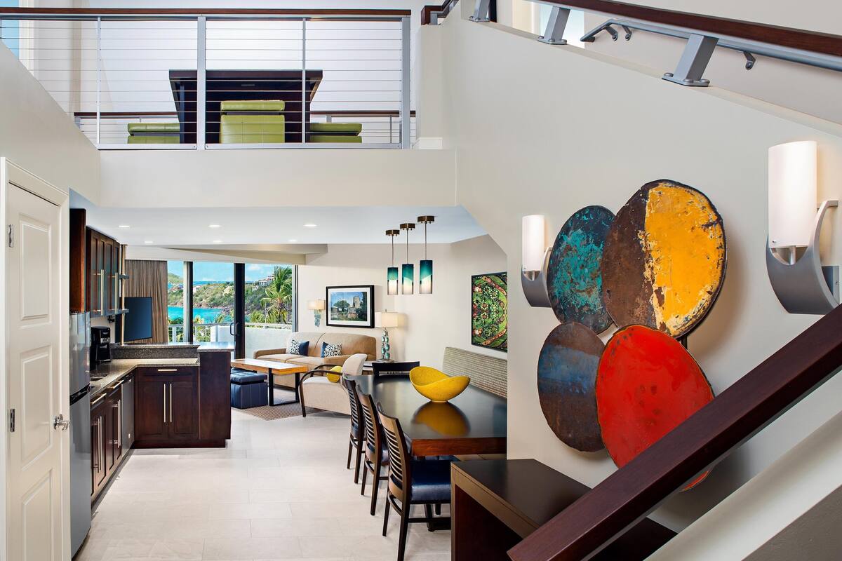 Un interior moderno con cocina, comedor y escalera.