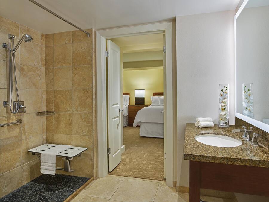 A hotel bathroom with a shower, toilet, and sink.