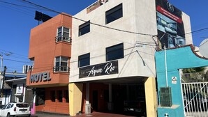 Un hôtel avec une enseigne indiquant « HÔTEL » et « AQUA Rio ».