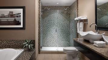 Une salle de bain moderne avec une douche à parois de verre, une baignoire, des toilettes et un lavabo.