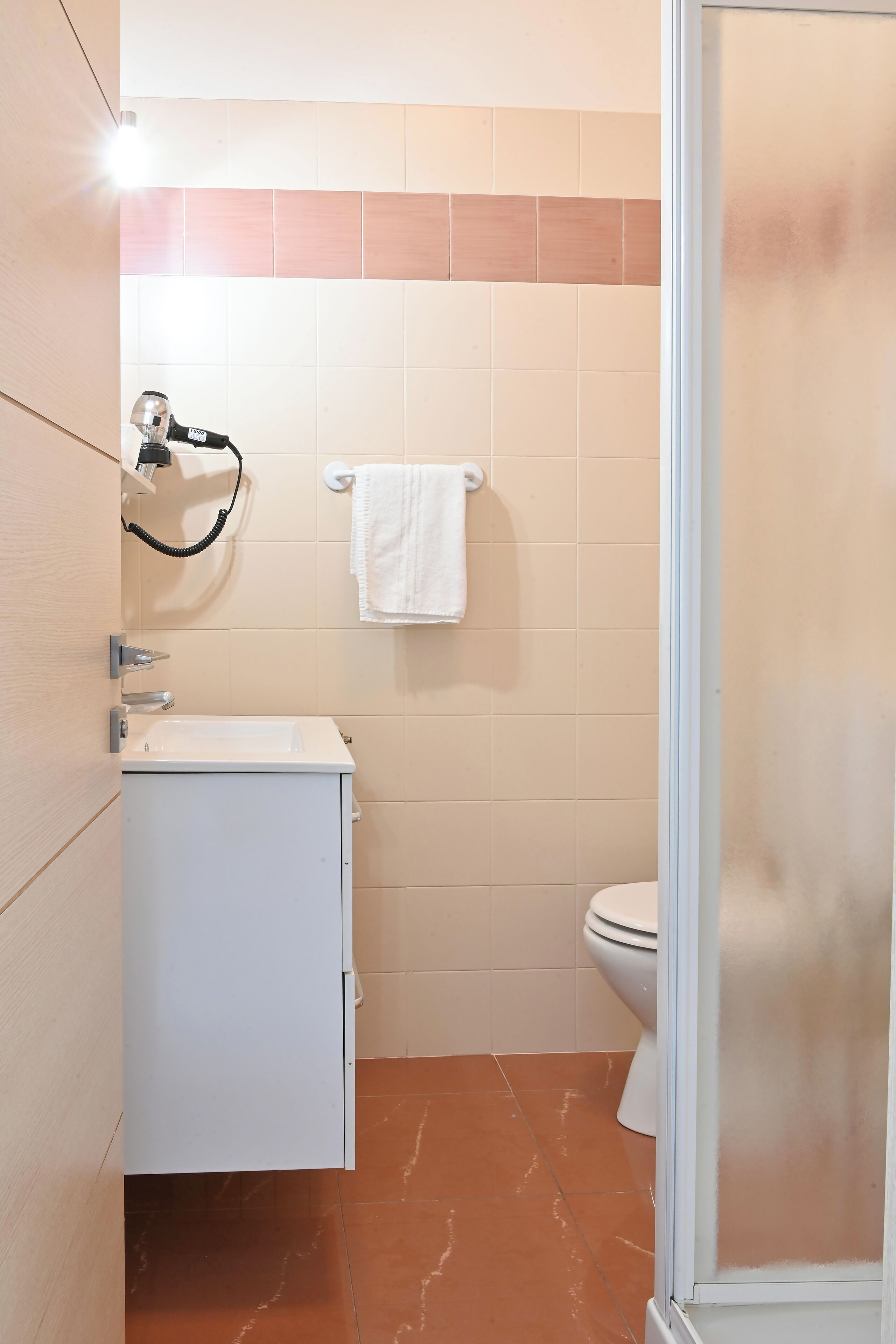 Une salle de bain avec un lavabo blanc, un porte-serviettes et des toilettes.