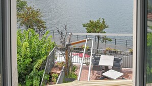 A view from a window overlooking a lake with a mountain in the background. - Hotel Marco's (Como)