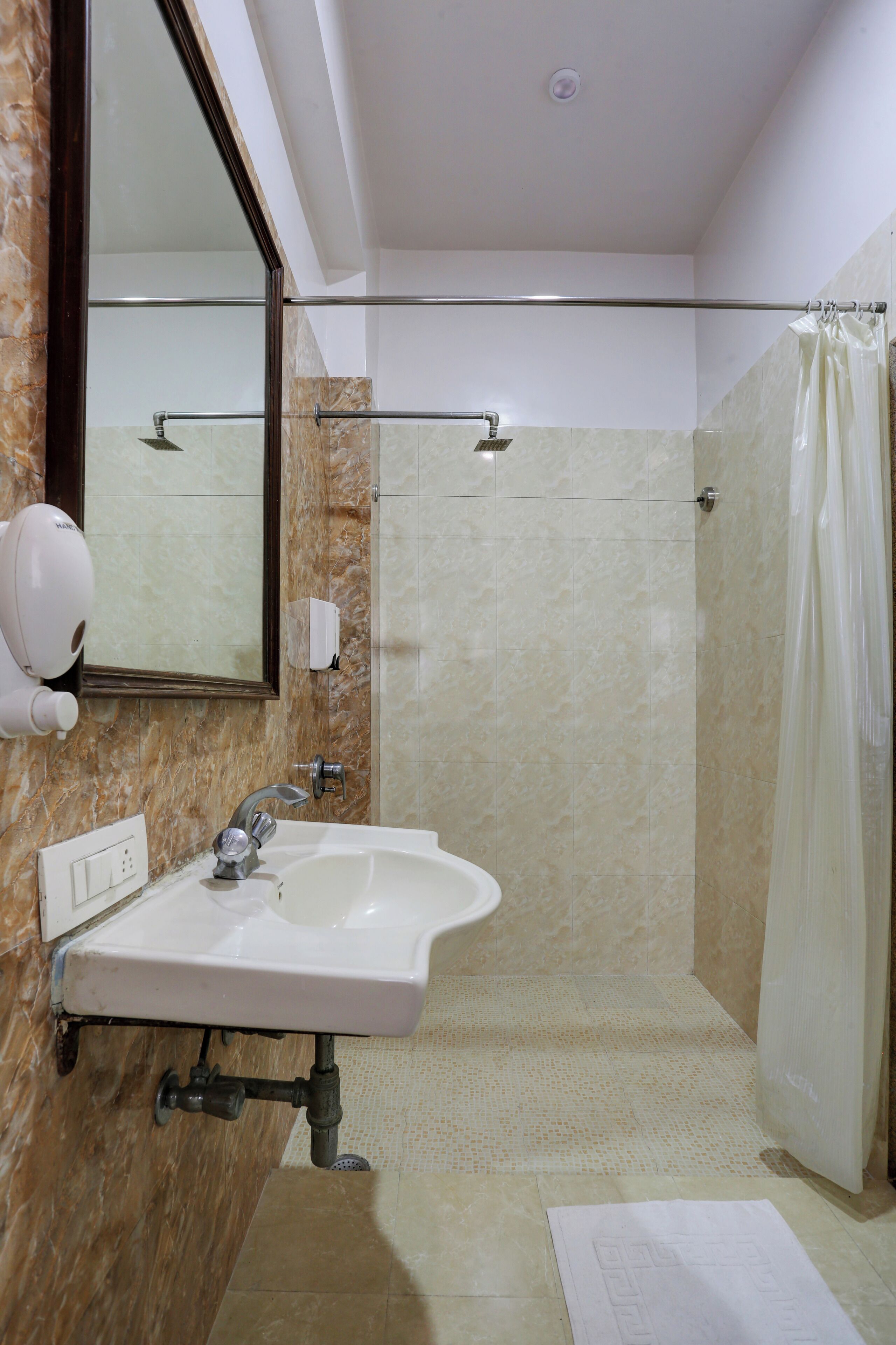 A bathroom with a sink, mirror, shower, and towel.