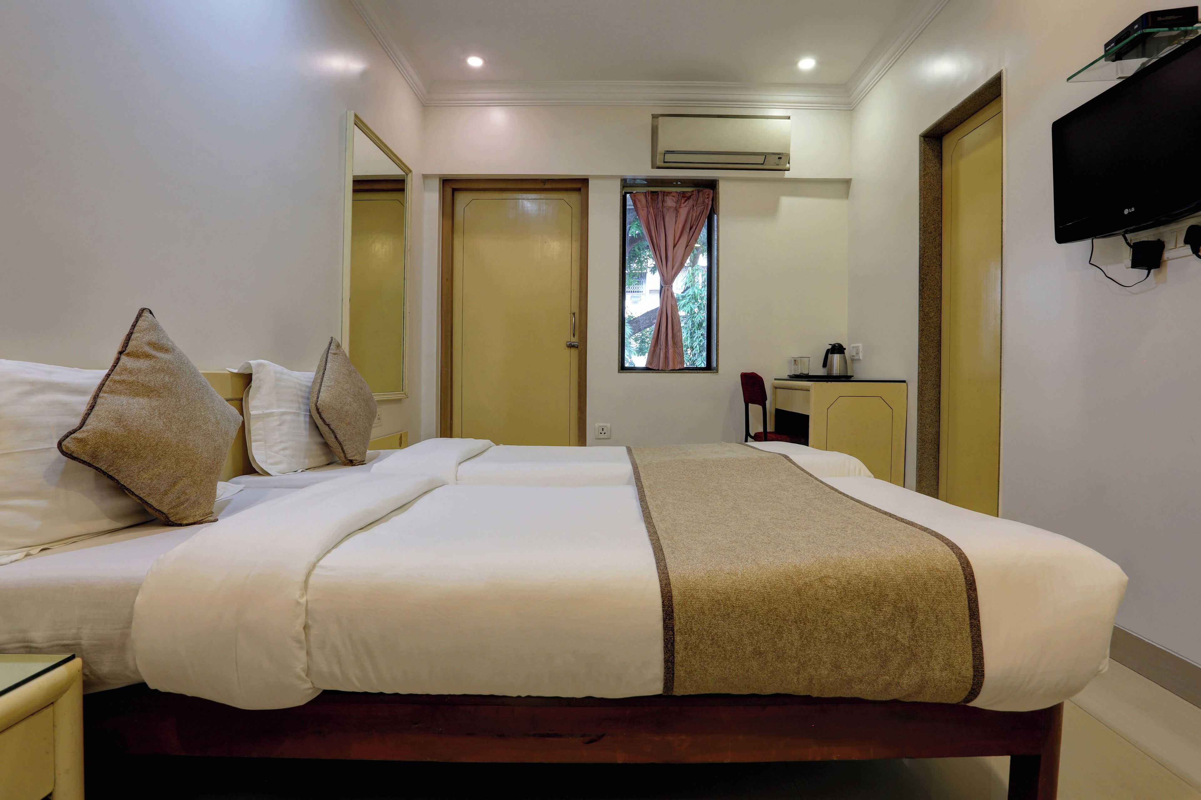 A hotel room with a large bed, a desk, and a television.