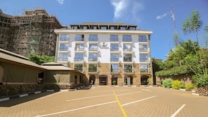A multi-story building with a parking lot in front. - Nairobi Upperhill Hotel (Nairobi)