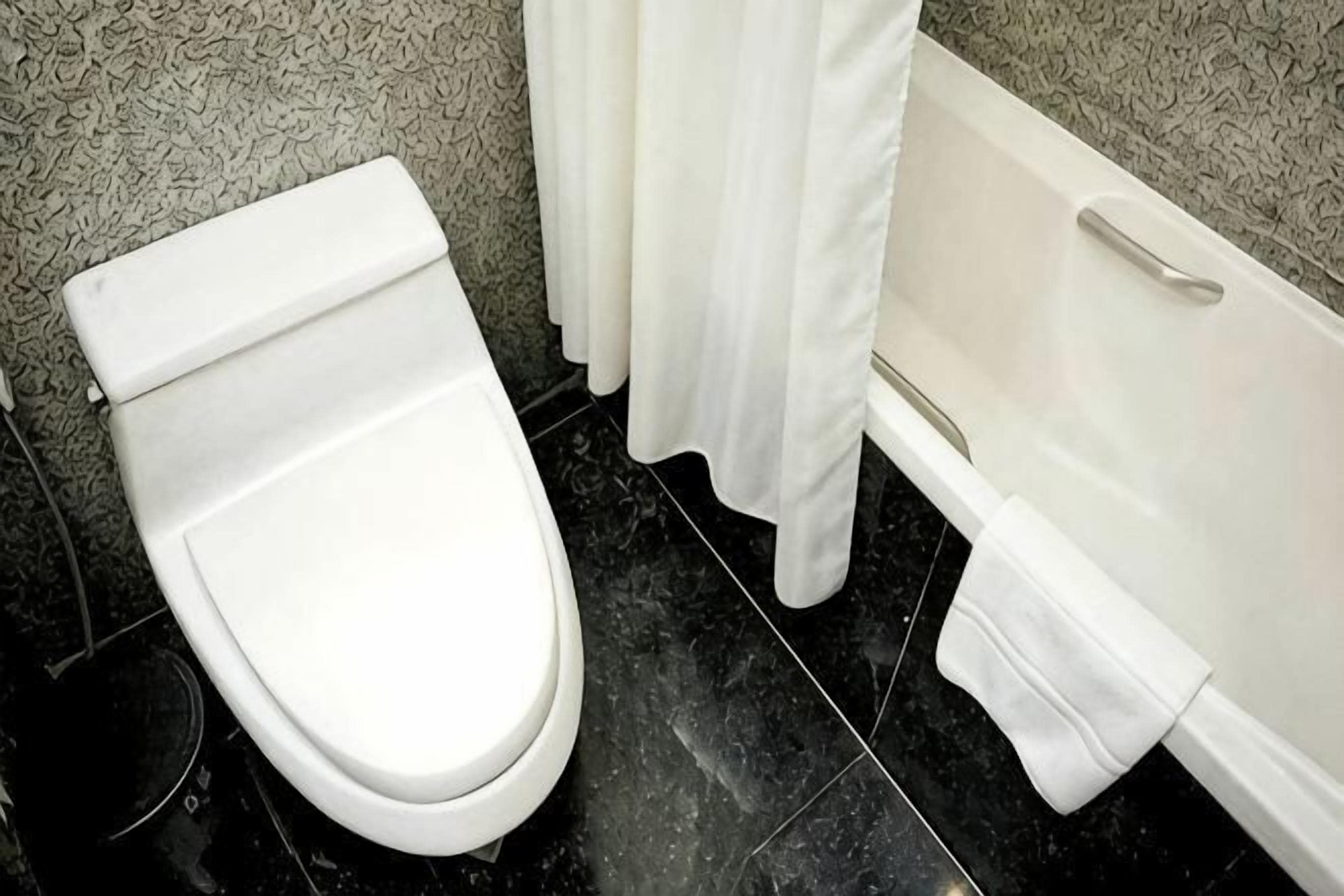 Et badeværelse med toilet, badekar og brusekabine.