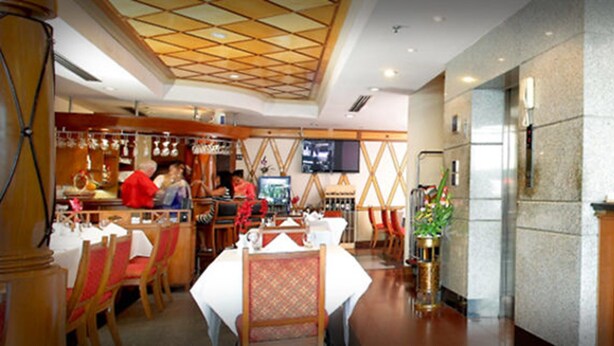 A reception area with a reception desk, a clock, and a wall-mounted sign that reads "RECEPTION". - Majestic Suites (Bangkok)