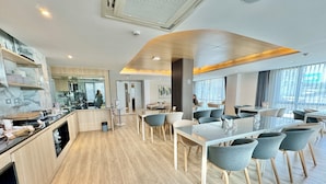 A modern dining area with wooden flooring, glass tables, and grey chairs. - Resort Bangphlat (Bangkok)