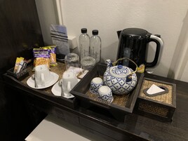 A breakfast tray with a teapot, cups, and condiments.