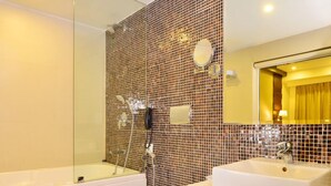 Een moderne badkamer met een bad, toilet en twee wasbakken.