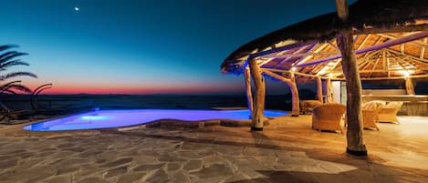 Una piscina al aire libre, sillones reclinables de piscina