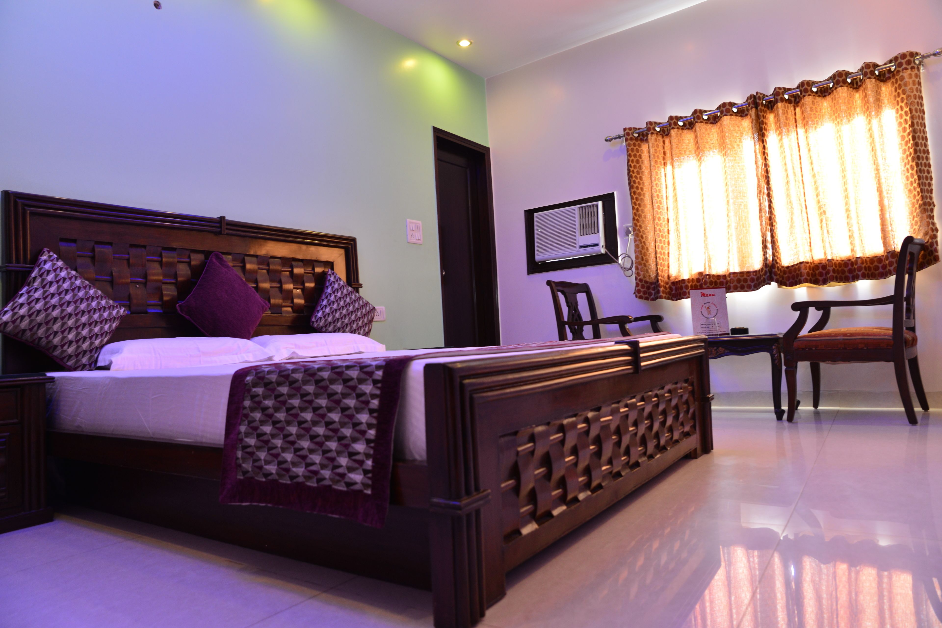 A bedroom with a bed, a desk, and a chair.