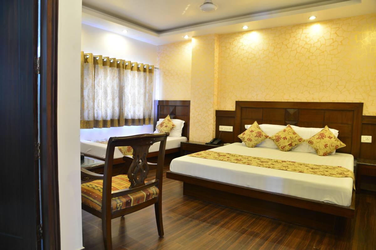 A hotel room with a large bed, a desk, and a chair.