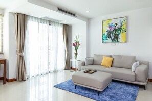 Deluxe suite, 1 slaapkamer, uitzicht op zwembad | Woonruimte | Een 40-inch televisie met kabelzenders