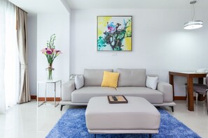 Deluxe suite, 1 slaapkamer, uitzicht op zwembad | Woonruimte | Een 40-inch televisie met kabelzenders