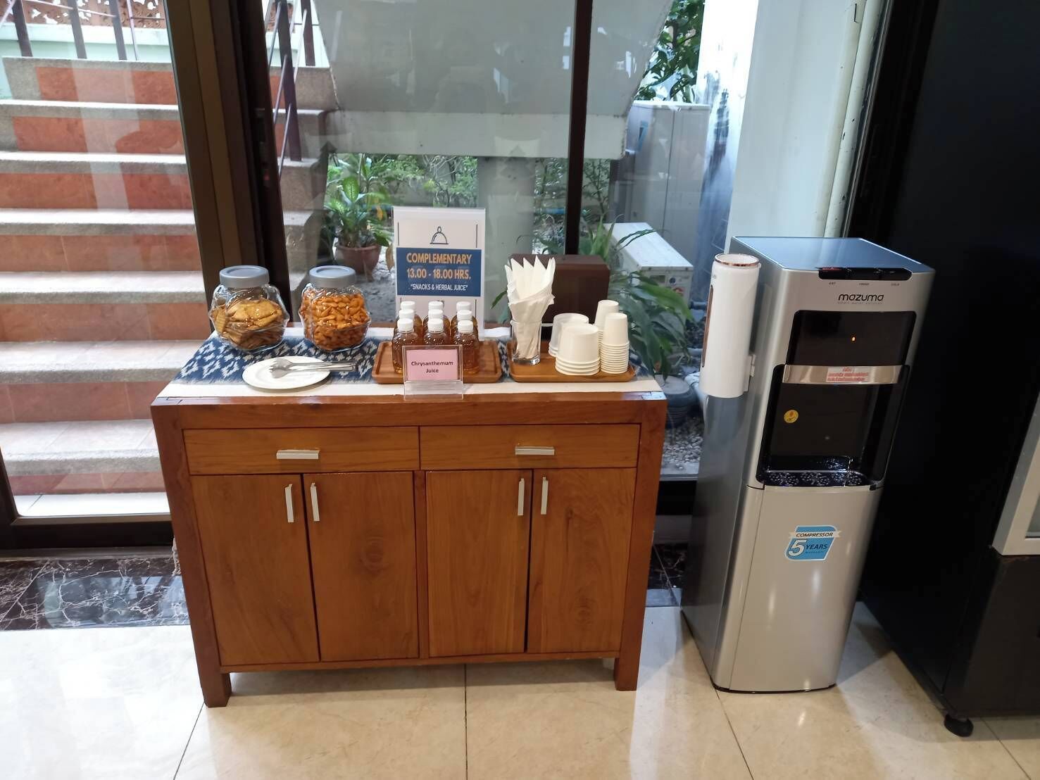 A breakfast station with a coffee machine, snacks, and juice dispensers.