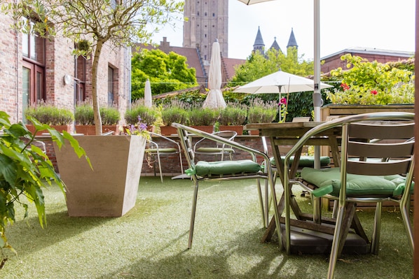An outdoor seating area with metal chairs and a large planter.