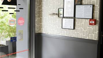 A door with a patterned wallpaper and a mounted animal head.