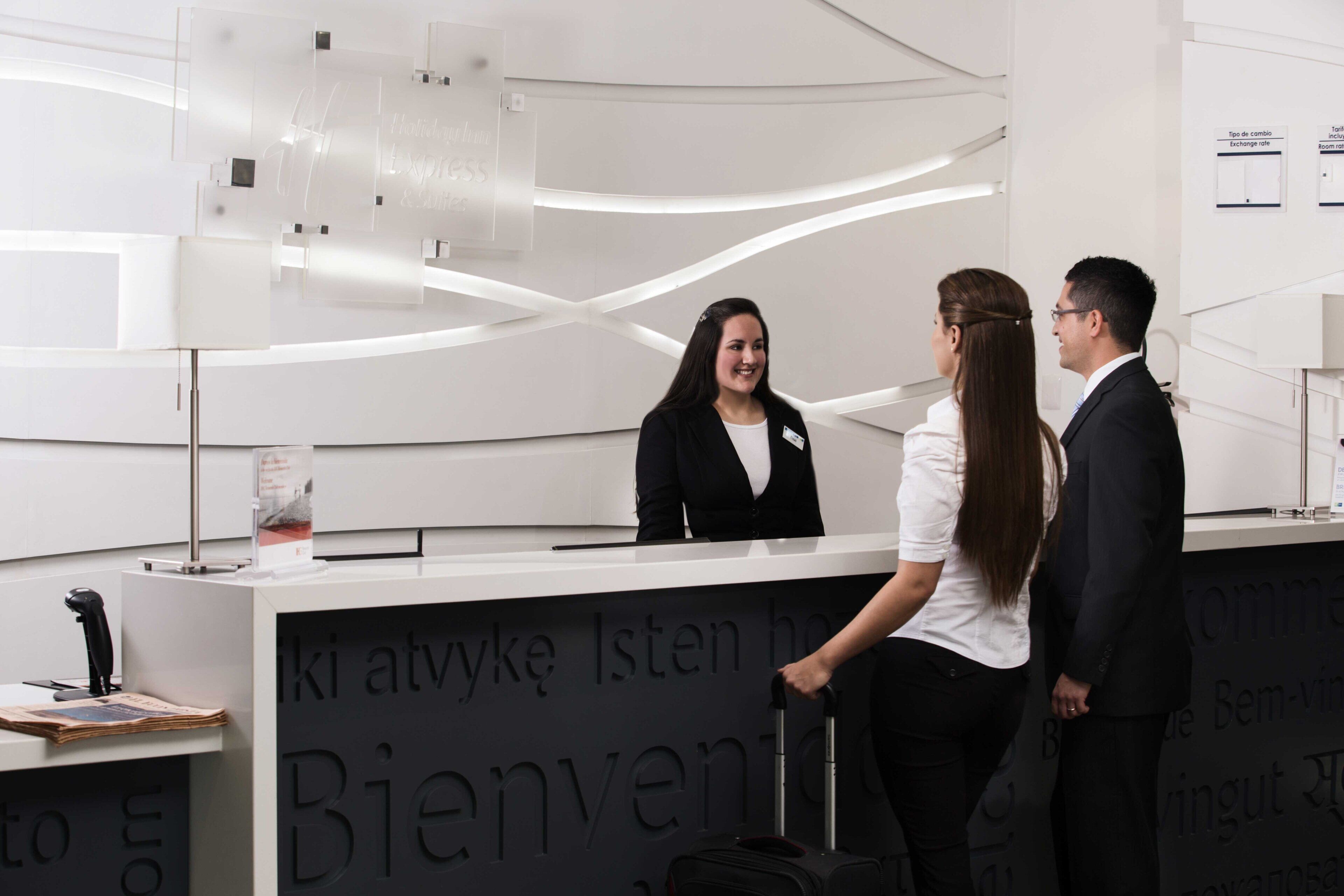 A reception desk with a modern design, featuring a nameplate and a sign with the word 'Bienvenue' indicating a welcoming area.