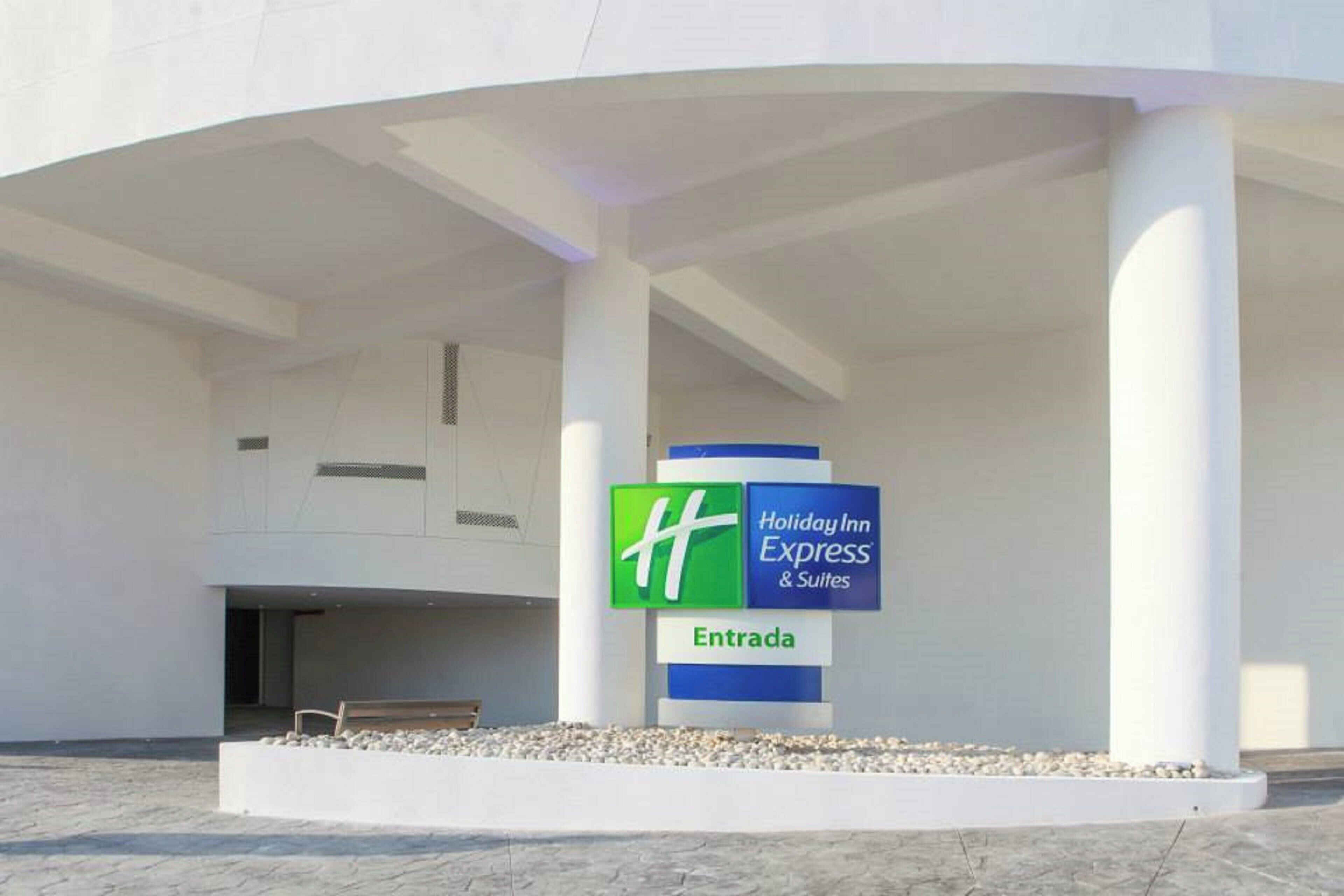 A hotel entrance with a sign for Holiday Inn Express & Suites.