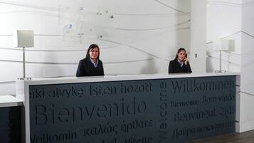 A reception desk with a sign displaying 'Welcome' in multiple languages.