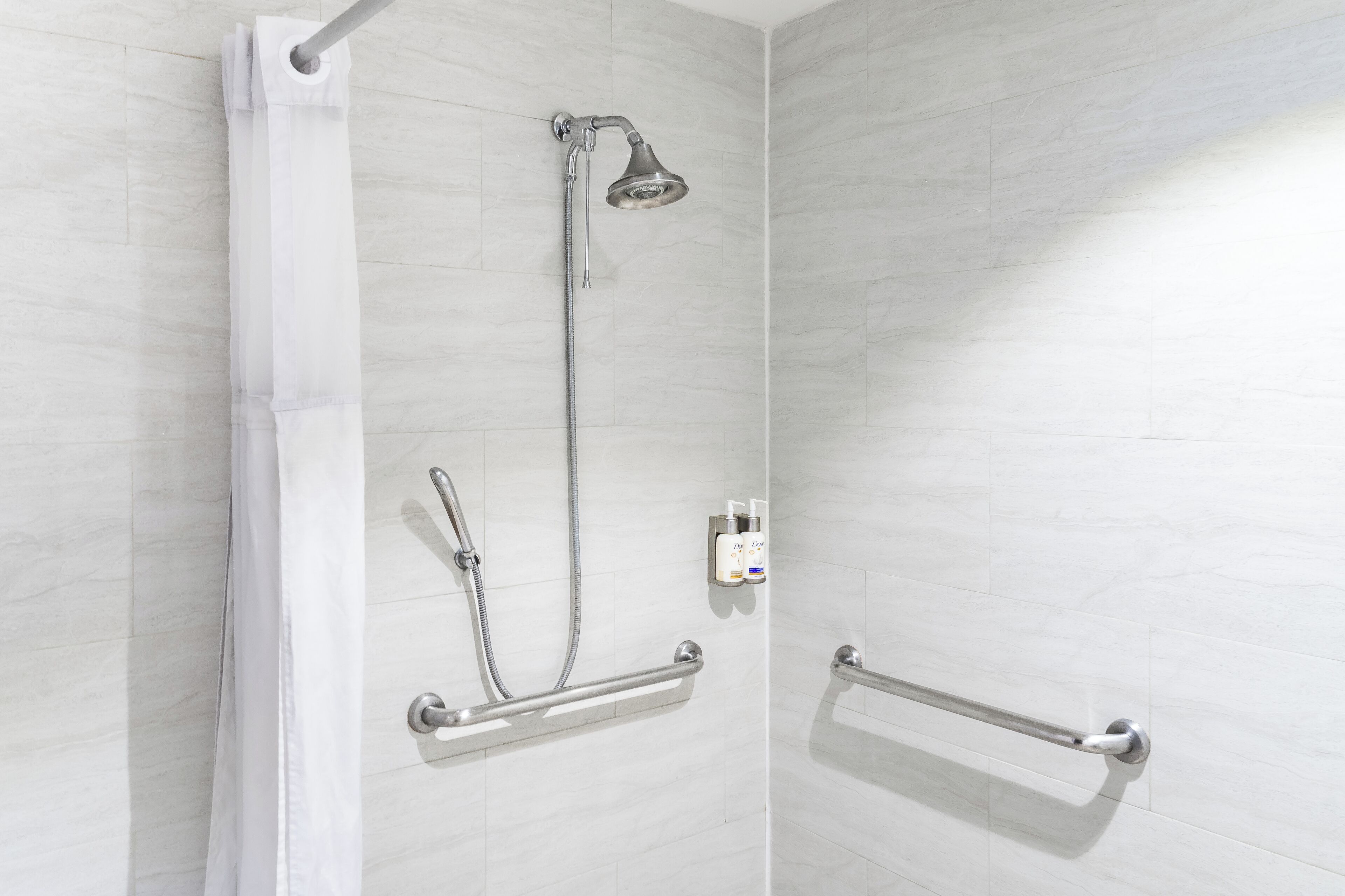 Ducha con cabezal de ducha de mano, accesorio de ducha de mano y barra de apoyo.