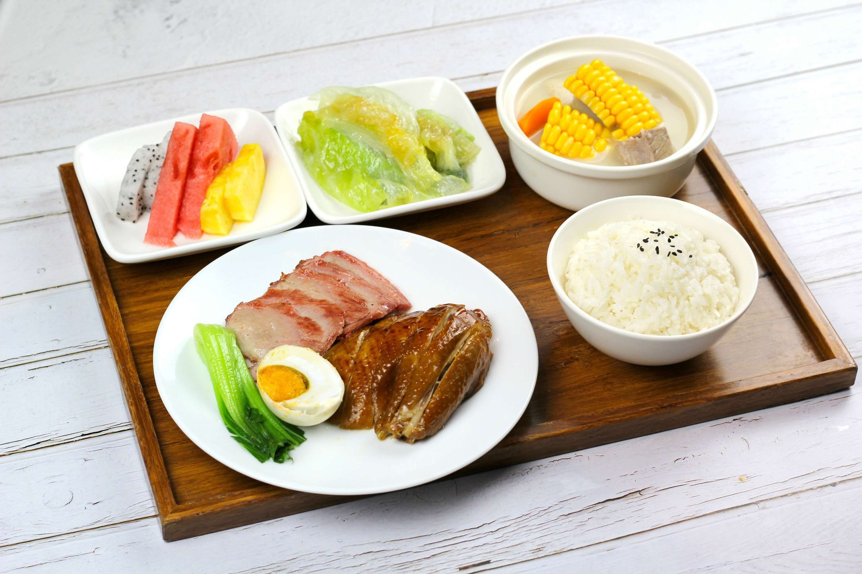 A meal tray with various dishes including meat, vegetables, and rice.