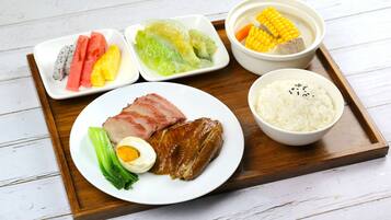 A meal tray with various dishes including meat, vegetables, and rice.