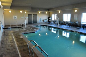 Una piscina techada, sillones reclinables de piscina